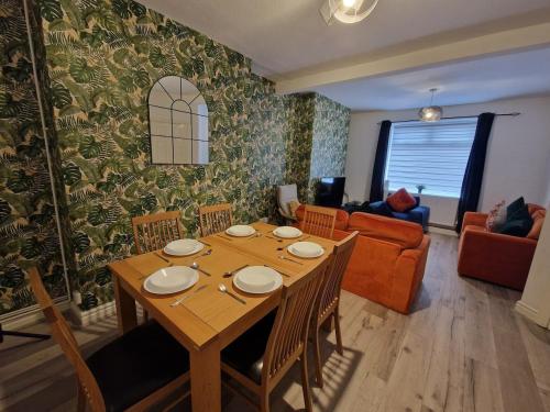 ein Esszimmer mit Tisch und ein Wohnzimmer in der Unterkunft SleepyStays 3 Bedroom Modern & Central Location in Merthyr Tydfil
