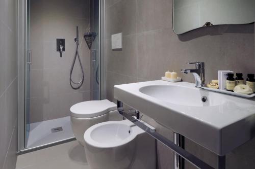 La salle de bains est pourvue d'un lavabo, de toilettes et d'une douche. dans l'établissement Locanda Fiorita, à Venise