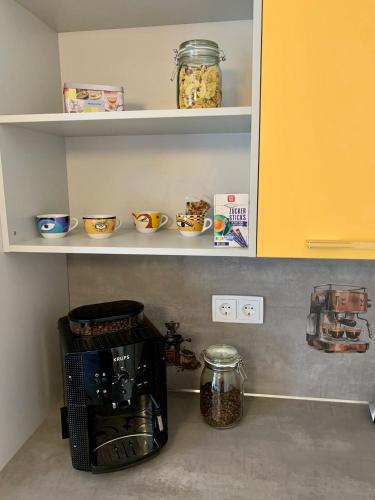 a kitchen shelf with bowls and a coffee maker on it at Ferienwohnung Dietel in Bad Schlema mit WLAN Terrasse Stellplatz inklusive in Schlema