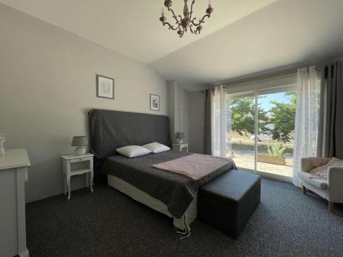 une chambre avec un lit et une grande fenêtre dans l'établissement Villa à Orgnac-l'Aven avec piscine chauffée, 6 pers, jardin clôturé, animaux admis - FR-1-382-127, à Orgnac-lʼAven