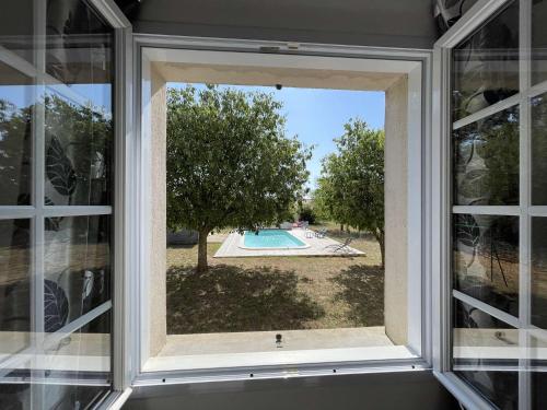 une fenêtre avec vue sur la piscine dans l'établissement Villa à Orgnac-l'Aven avec piscine chauffée, 6 pers, jardin clôturé, animaux admis - FR-1-382-127, à Orgnac-lʼAven
