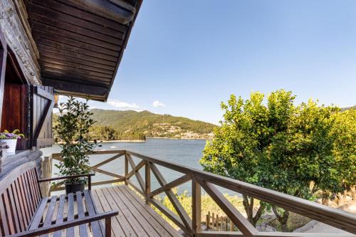 a porch with a bench and a view of a river at Bungalow Chalé da Caniçada in Rio Caldo