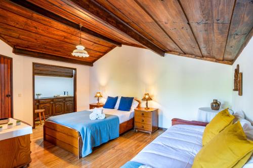 two beds in a room with wooden ceilings at Bungalow Chalé da Caniçada in Rio Caldo