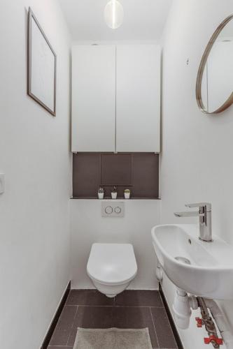 une salle de bain blanche avec des toilettes et un lavabo dans l'établissement Beautiful Loft Duplex 6P AC Heart of Marais, à Paris