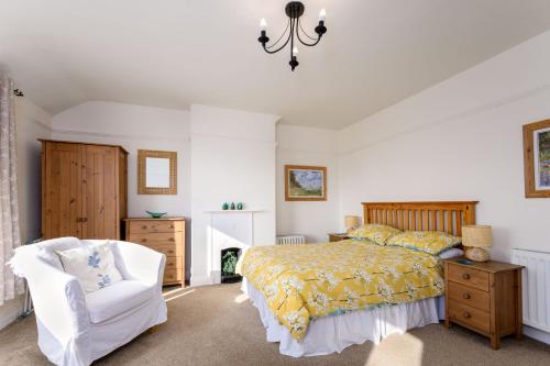 a bedroom with a bed and a chair at Cosy country cottage, nearby beaches attractions A55 in Llysfaen