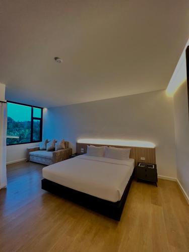 a bedroom with a large bed and a couch at PP Sweet House Khaolak พีพี สวีทเฮ้าส์ เขาหลัก in Ban Lam Ru (1)