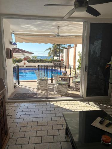 an open door to a patio with a view of a pool at Playa Bonita unit Beso del Sol 101 in Puerto Vallarta