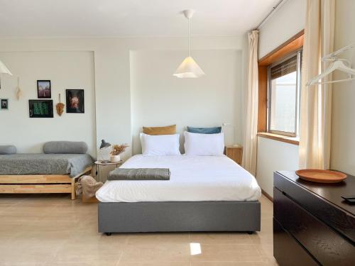 a bedroom with a bed and a dresser and a desk at Casa Guilhermina, Sunny Studio with Balcony in Porto