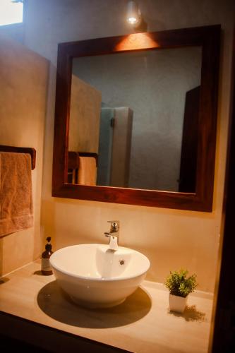 a bathroom with a white sink and a mirror at Hotel Boutique Villa Ka'an in Calderitas