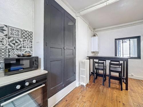 une petite cuisine avec une table et un micro-ondes dans l'établissement Charmant Appartement CL-FD Centre Historique Marché aux poissons B, à Clermont-Ferrand