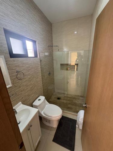 a bathroom with a toilet and a sink and a shower at 2br 1ba Condo 1 block to ocean Condo 1 in Mazatlán