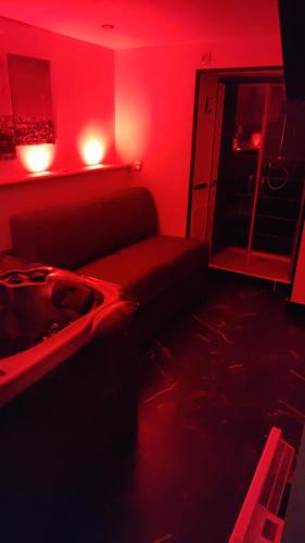 sala de estar con sofá en una habitación roja en Chambre privée Cosy à proximité de Roissy, Parc Astérix, en Fosses