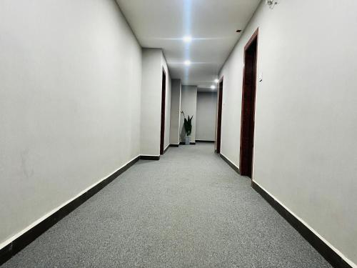 a hallway with white walls and a hallway with doors at Harvey's Hotels - Gowlidoddy - Near US Consulate in Hyderabad