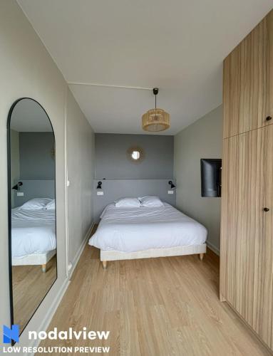 une chambre avec deux lits et un miroir dans l'établissement Cozy renovated apartment with cinema atmosphere and view, à La Mulatière