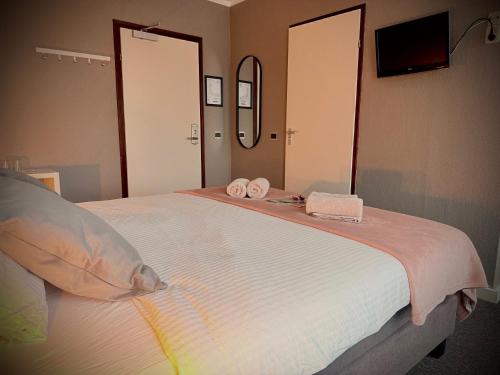a bedroom with a large bed with two towels on it at Hotel Restaurant 't Ronde Loegh in Winschoten