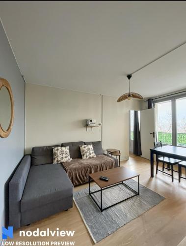 un salon avec un canapé et une table dans l'établissement Cozy renovated apartment with cinema atmosphere and view, à La Mulatière