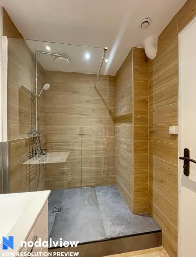La salle de bains est pourvue d'une douche et de murs en bois. dans l'établissement Cozy renovated apartment with cinema atmosphere and view, à La Mulatière