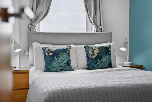 a bedroom with a bed with two pillows at The Pinnacle by Cotels - CENTRAL LOCATION, PARKING, FIBRE WIFI, SMART TV, FULLY EQUIPPED KITCHEN in Northampton