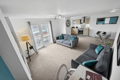 a living room with a couch and a chair at The Pinnacle by Cotels - CENTRAL LOCATION, PARKING, FIBRE WIFI, SMART TV, FULLY EQUIPPED KITCHEN in Northampton
