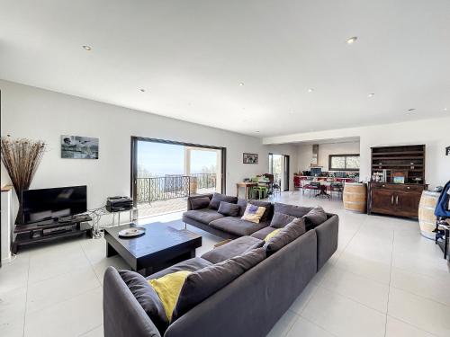 un grand salon avec un canapé et une télévision dans l'établissement Au parfum de la Myrte, à Olmeto