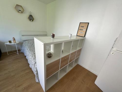 - une chambre avec un lit et une commode blanche dans l'établissement Appartement paisible avec stationnement gratuit, à Mulhouse