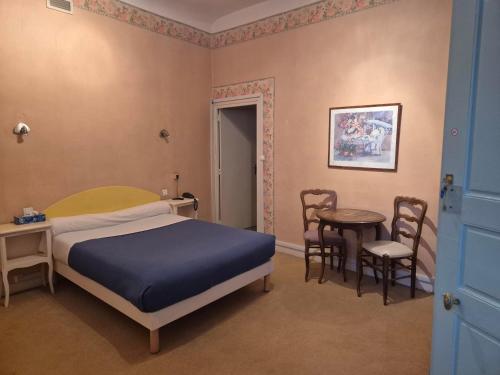 a bedroom with a bed and a table and chairs at Hotel Saint Jean in Chalon-sur-Saône