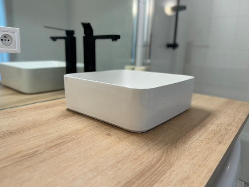 - un lavabo blanc sur un comptoir dans la salle de bains dans l'établissement Appartement paisible avec stationnement gratuit, à Mulhouse
