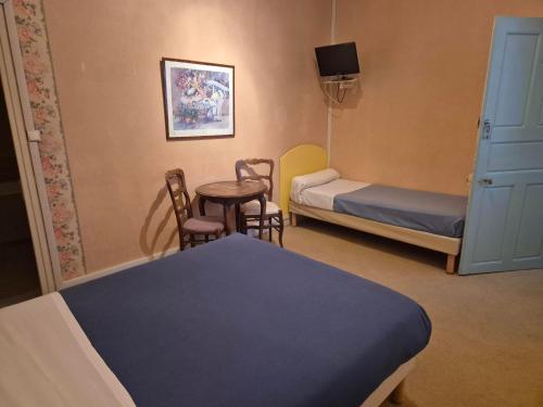 a room with two beds and a table and chairs at Hotel Saint Jean in Chalon-sur-Saône