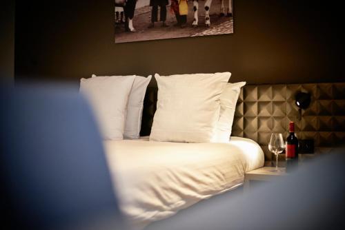 a bed with white sheets and pillows in a room at C-Hotels Westwing - ex Mercure in Roeselare