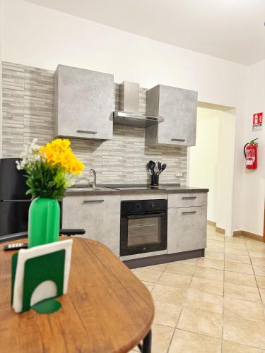 a kitchen with a wooden table with a vase of flowers at CyO Apartment 2 in Boscotrecase