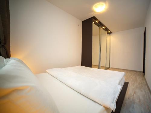a bedroom with a white bed and a mirror at PaulMarie Apartments on Volotovskaya in Gomel