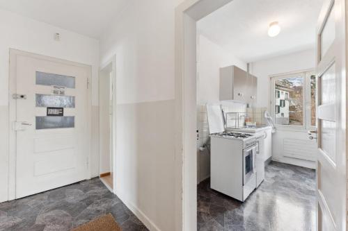 eine Küche mit weißen Schränken und einem Herd mit Backofen in der Unterkunft Basic Apartment with Full Kitchen in Zürich