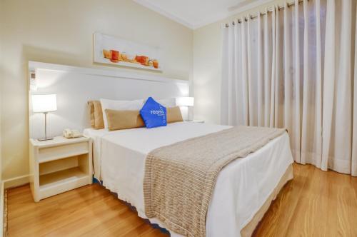 a bedroom with a bed with a blue pillow on it at Roomo Transamerica SP Itaim Bibi in Sao Paulo