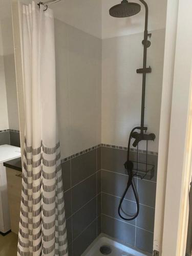 une douche avec un rideau de douche dans une salle de bain dans l'établissement Appartement tout confort climatisé, à Gruissan