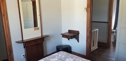 a bedroom with a mirror and a bed and a stool at Motel et Chalets Bo-Fleuve Evangeline in Saint-Siméon