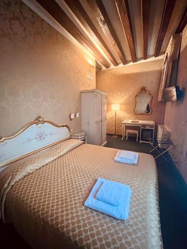 a bedroom with a bed with two towels on it at Locanda Correr in Venice
