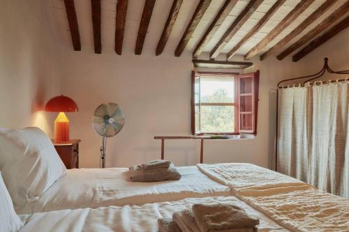 1 dormitorio con 1 cama, ventana y ventilador en Casale Toscano a Lucca, en Lucca