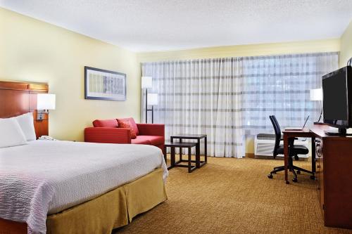 a hotel room with a bed and a desk at Heritage Place Houston Brookhollow in Houston