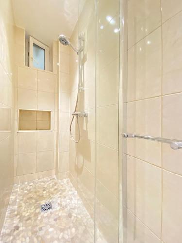 une salle de bain avec une douche avec une porte vitrée dans l'établissement Lovely flat 75m2 close to Eiffel Tower, à Paris