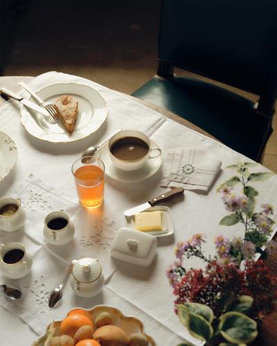a table with a plate of food and a cup of coffee at Le château de Bonnemare - Bed and breakfast in Radepont