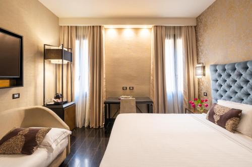 a hotel room with a large bed and a desk at The Venice Times in Venice