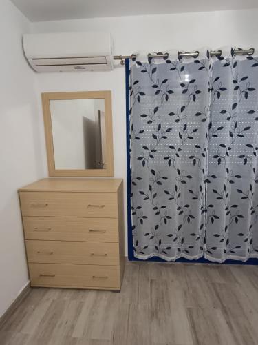 a bedroom with a dresser and a mirror at Haraki Blue Houses in Haraki