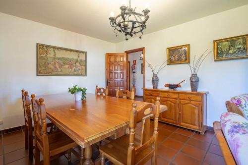 a dining room with a wooden table and chairs at Hotel Casa Rectoral in Tui