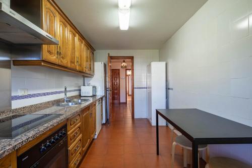a kitchen with wooden cabinets and a black counter top at Hotel Casa Rectoral in Tui