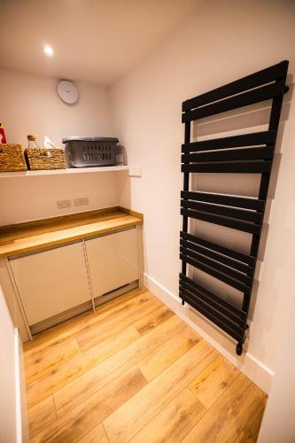 a walk in pantry with black shelves and wood floors at Thistle Lodge in Comrie