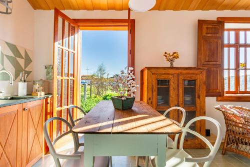 a dining room with a wooden table and chairs at Green Dunes House in Arcozelo
