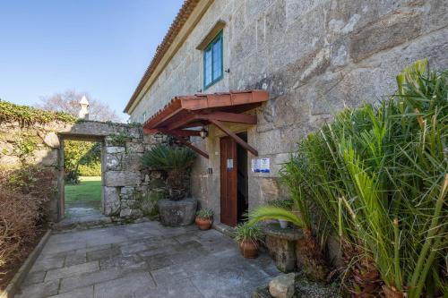 an entrance to a stone building with a wooden door at Hotel Casa Rectoral in Tui