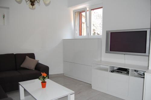 sala de estar con TV, sofá y mesa en Beach House Tribunj en Tribunj