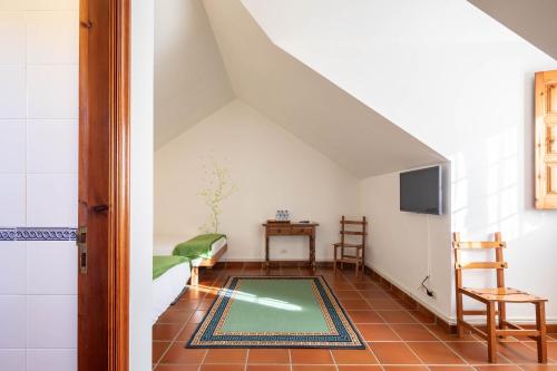 an attic room with a rug on the floor at Hotel Casa Rectoral in Tui