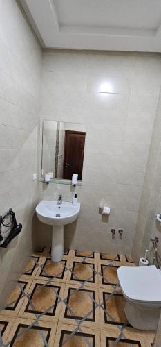a bathroom with a sink and a mirror and a toilet at Ryad 91 in Casablanca